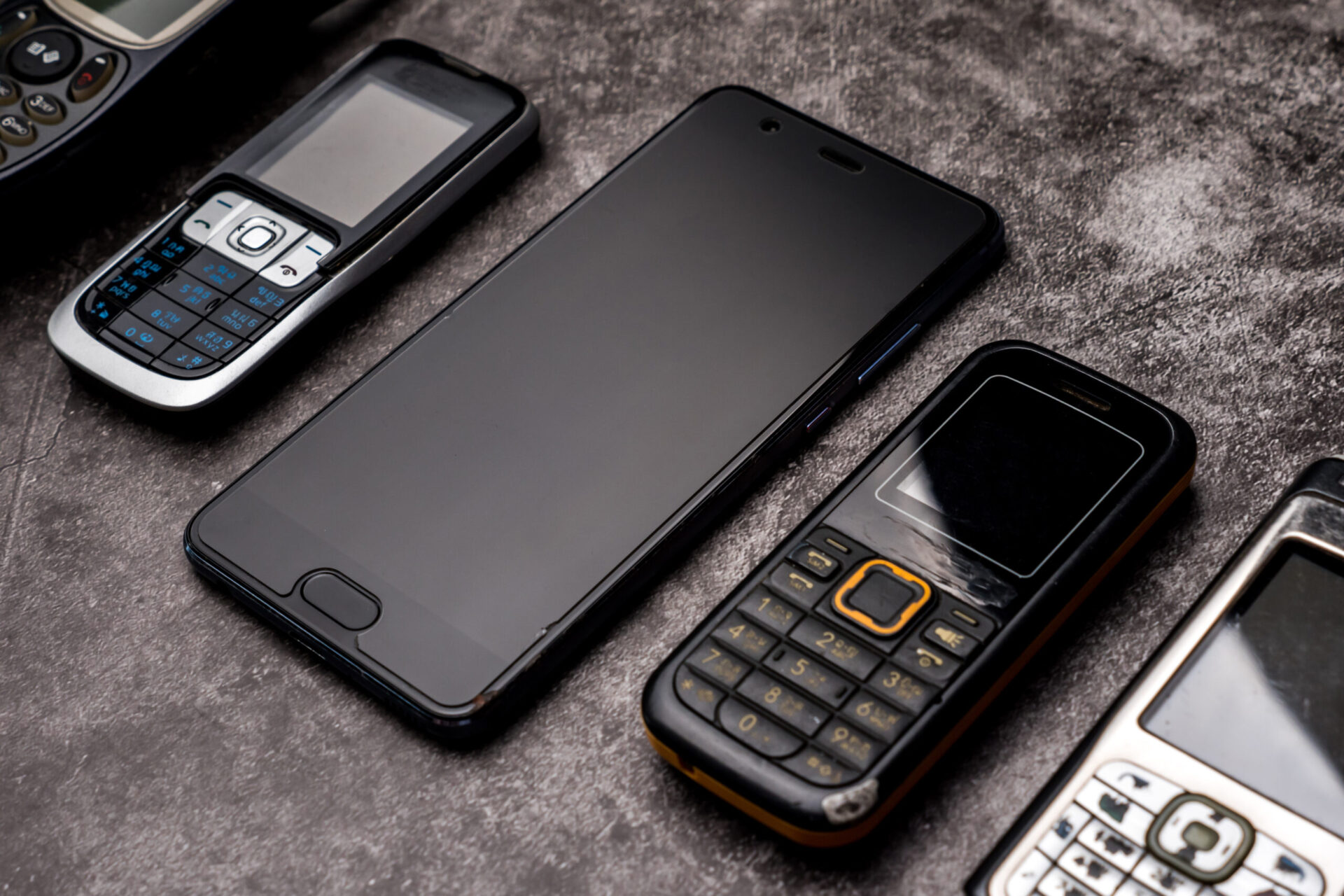 old mobile phones on a dark grey background